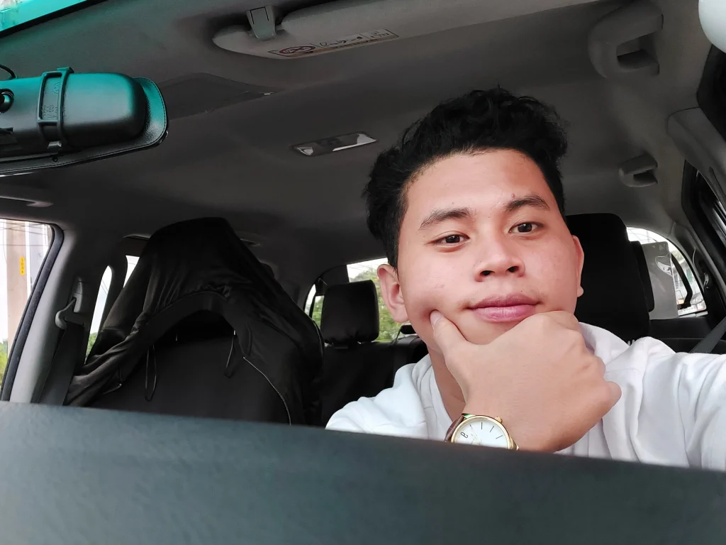 Ralf Alexis Perino sitting inside a car wearing a white shirt